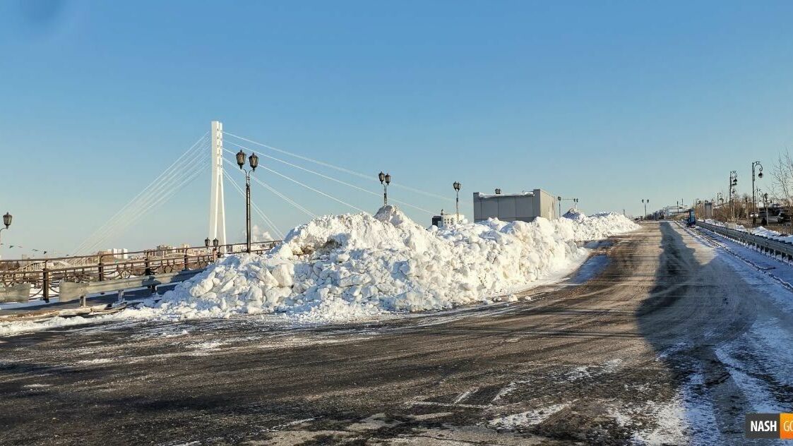 Горы снега появились на платной парковке у моста Влюбленных в Тюмени