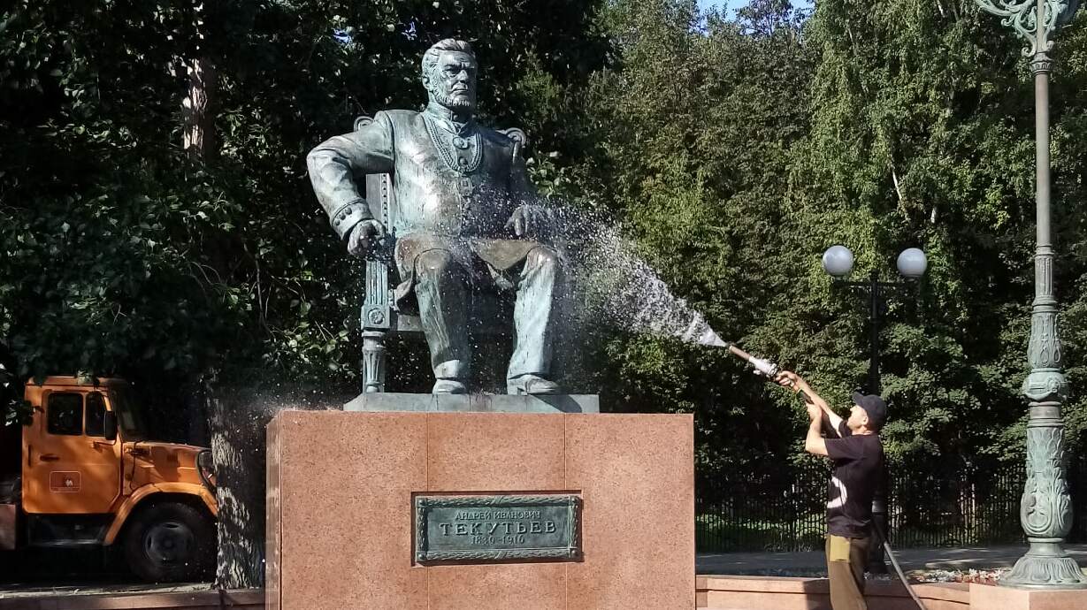 Работник "Вереска" поливает текутьева со своего шланга 